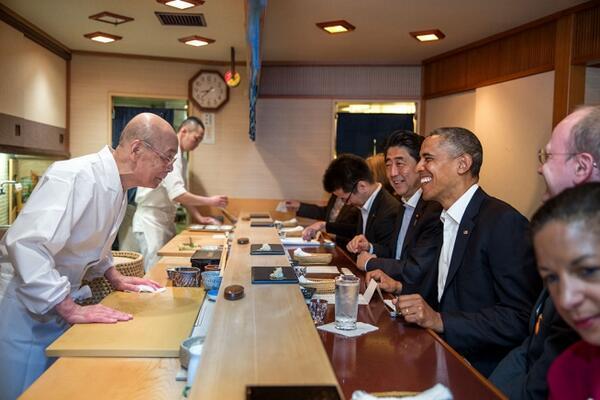 Президента Барака Обаму приветствует мастер суши Джиро Оно, владелец ресторана суши в Токио, во время частного обеда с премьер-министром Японии Синзо Абэ. 23 апреля 2014 г.