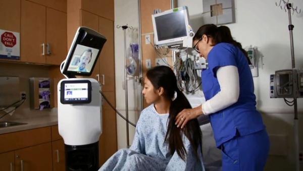 Врач на экране робота RP-VITA просит медсестру приложить стетоскоп к спине пациентки. Photo Courtesy: i-Robot & InTouch Health