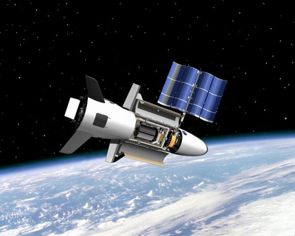 Корабль-робот X-37B компании «Боинг» в автономном полете на околоземной орбите. Видна развернутая солнечная батарея, энергии которой вполне достаточно для работы всех приборов и маневрирования на орбите. Иллюстрация художника.