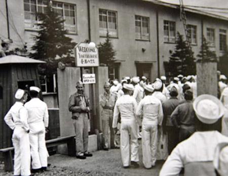 На этой фотографии, распространенной горсоветом японского города Йокосука (к югу от Токио), американские моряки собрались у входа в «комфортную станцию» Ясу-Ура в Йокасуке.( приб. 1946 г.)