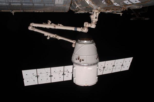 Вид с Международной космической станции (вверху) на пристыковывающийся с помощью механической руки корабль «Драгон». 25 мая 2012 года. Photo Credit: NASA