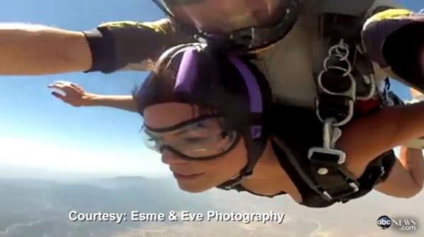 Парашютный прыжок Марисы Галлегос снимает на видео инструктор по прыжкам с парашютом (он сверху от Марисы), к которому цепями прикреплена сама прыгающая. 