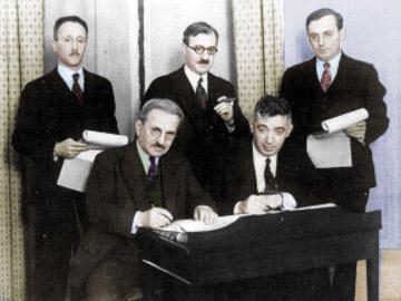 А. Кан и С.Г. Брон подписывают контракт в 1930 г. В центре стоит Морис Кан (брат), по бокам — адвокаты. (с разрешения С.М. Мельниковой-Рэйч)