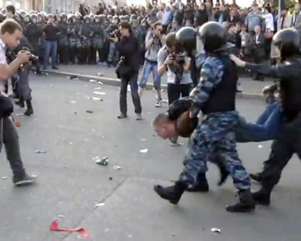 6 мая 2012 г. ОМОН арестовывает и несет митингующего на Болотной площади в автозак. Photo Courtesy: YouTube