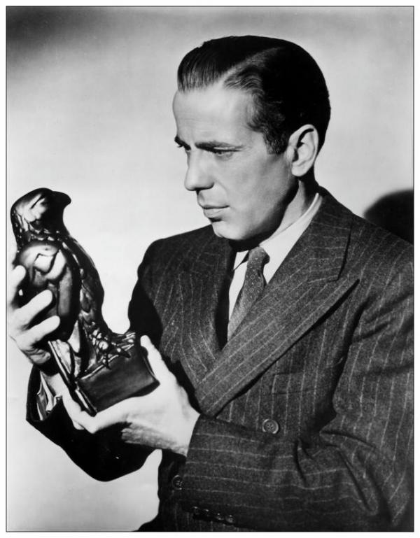 Хэмфри Богарт со статуэткой  мальтийского сокола в одноименном фильме 1941 года