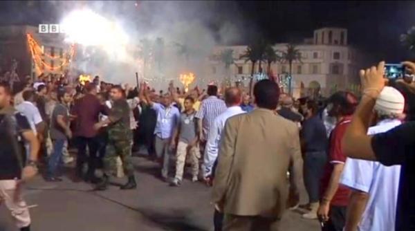 Толпы людей собрались в Триполи на Площади мучеников, чтобы отпраздновать начало работы демократически избранного нового парламента Ливии. Более 100 партий боролись за право войти в новый парламент. Кадр видео BBC.