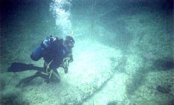 Американские подводные исследователи Грег и Лора Литтл обнаружили на глубине около 6 метров в районе Багамских островов дорогу, выложенную каменными плитами, размером 2-3 метра каждая. Плиты, как полагают, были обработаны – вручную или механическим путем. Позднее Грег и Лора открыли под водой на глубине около 3 метров еще одну гигантскую каменную дорогу вблизи багамского острова Андрос, рядом с городком Николс, в 100 милях от «Дороги Бимини». Супруги Литтл назвали ее «Платформой Андроса».  Платформа выложена огромными плоскими каменными плитами до 9 метров в длину и 6 метров в ширину. Обе дороги находятся недалеко от обнаруженного источника аномального излучения. (Photo courtesy: History Channel).
