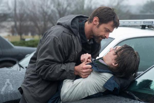 Хью Джекман (играющий отца пропавшего ребенка) пытает Пола Дано (играющего подозреваемого в похищении).  © 2013 Alcon Entertainment, LLC