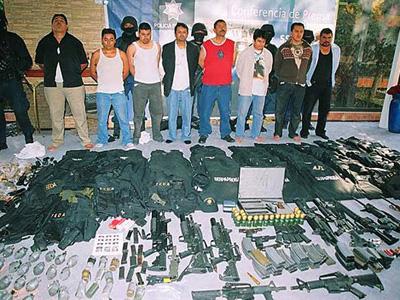 Рядовых членов картеля Синалоа время от времени мексиканская полиция ловила, демонстрируя общественности самих бандитов и их вооружение. Снимок 2008 года. 