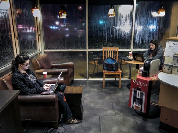 В темную дождливую ночь в кофейне Starbucks в Сакраменто две девушки работают на своих лэптопах, пользуясь бесплатным Wi-Fi. Теперь, благодаря Google, скорость соединения с интернетом в Starbucks через Wi-Fi возросла в 10 раз. Photo by Robert Couse-Baker / Flickr  